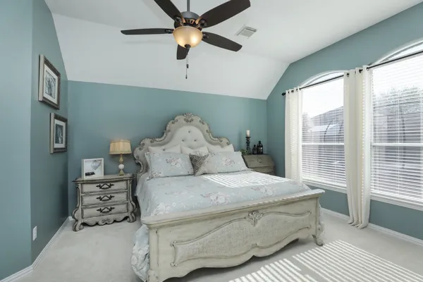 a bedroom with a large bed and a chandelier