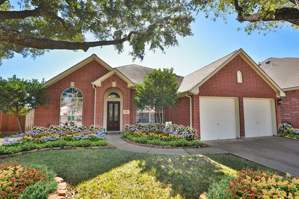 a front view of a house with a yard and potted plants