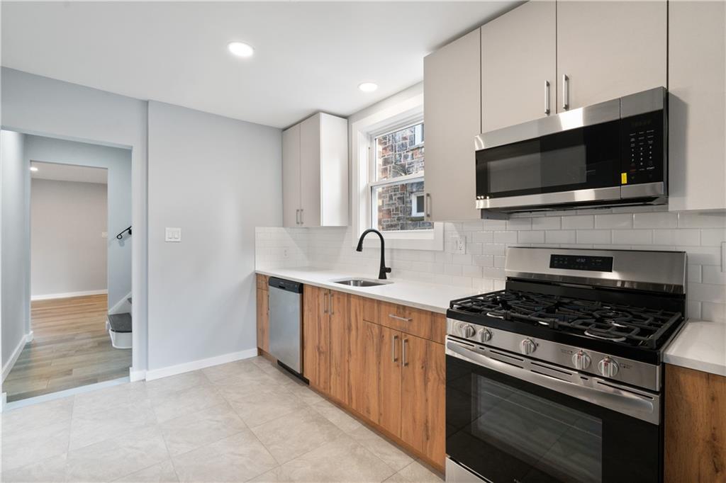 3030 Shady Avenue Pittsburgh, PA 15217 - Photo 11 of 31 a kitchen with stainless steel appliances a stove microwave and sink