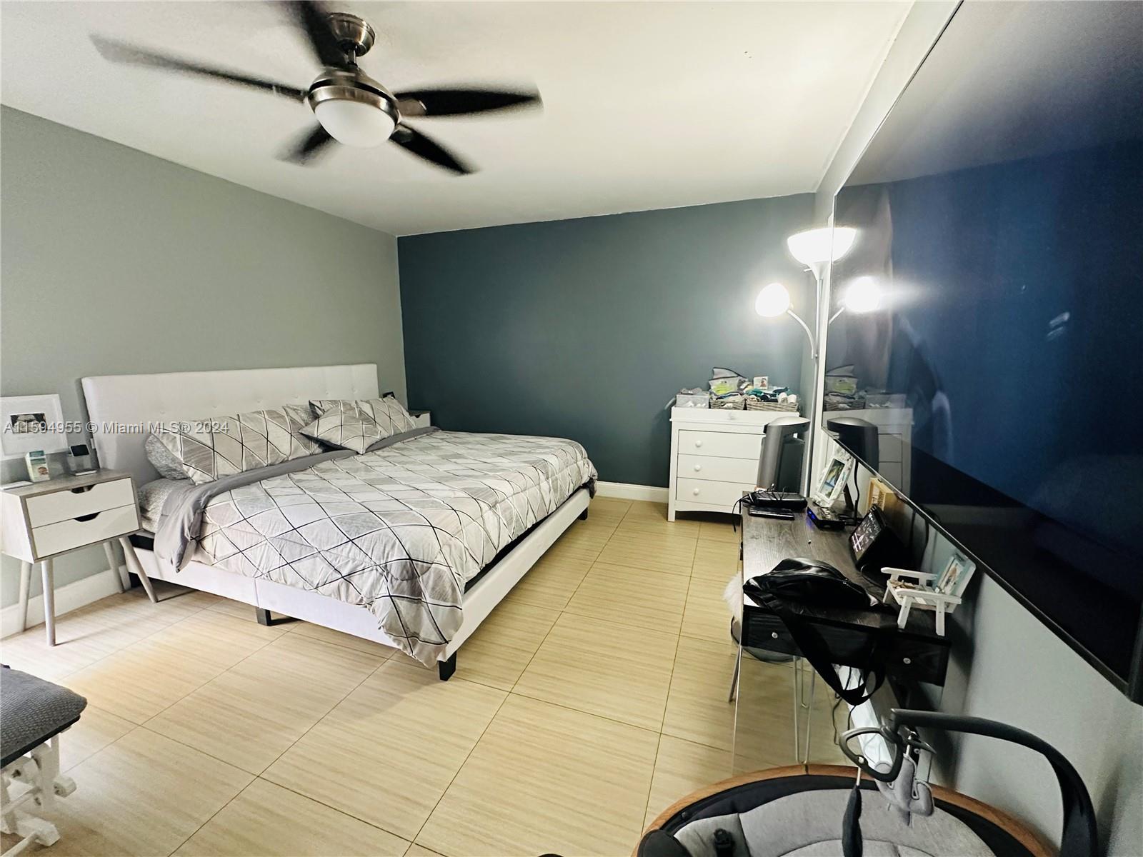 15056 Southwest 127th Place Miami, FL 33186 - Photo 13 of 25 a bedroom with a bed and wooden floor