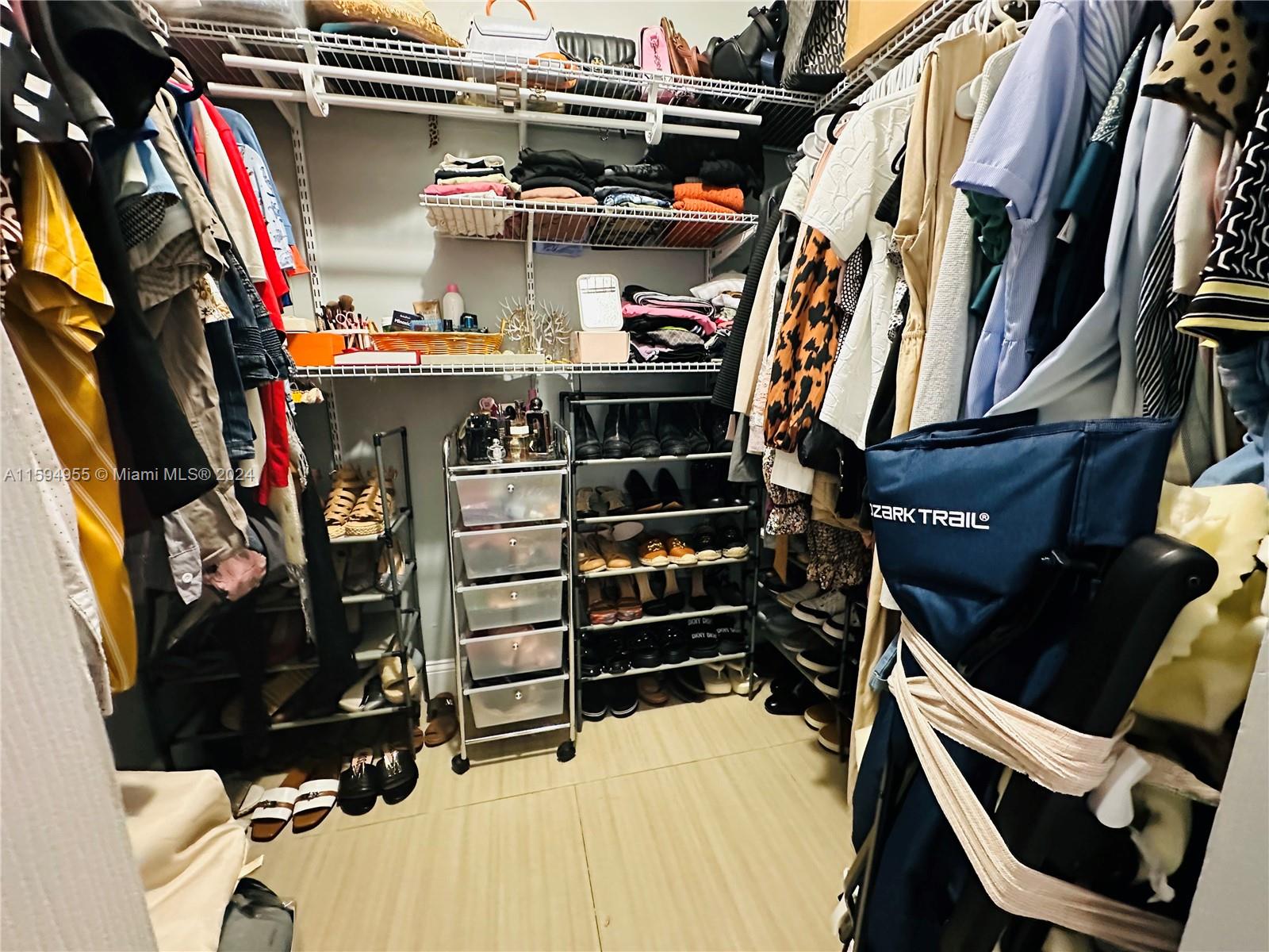 15056 Southwest 127th Place Miami, FL 33186 - Photo 14 of 25 a view of walk in closet with clothes and shoes