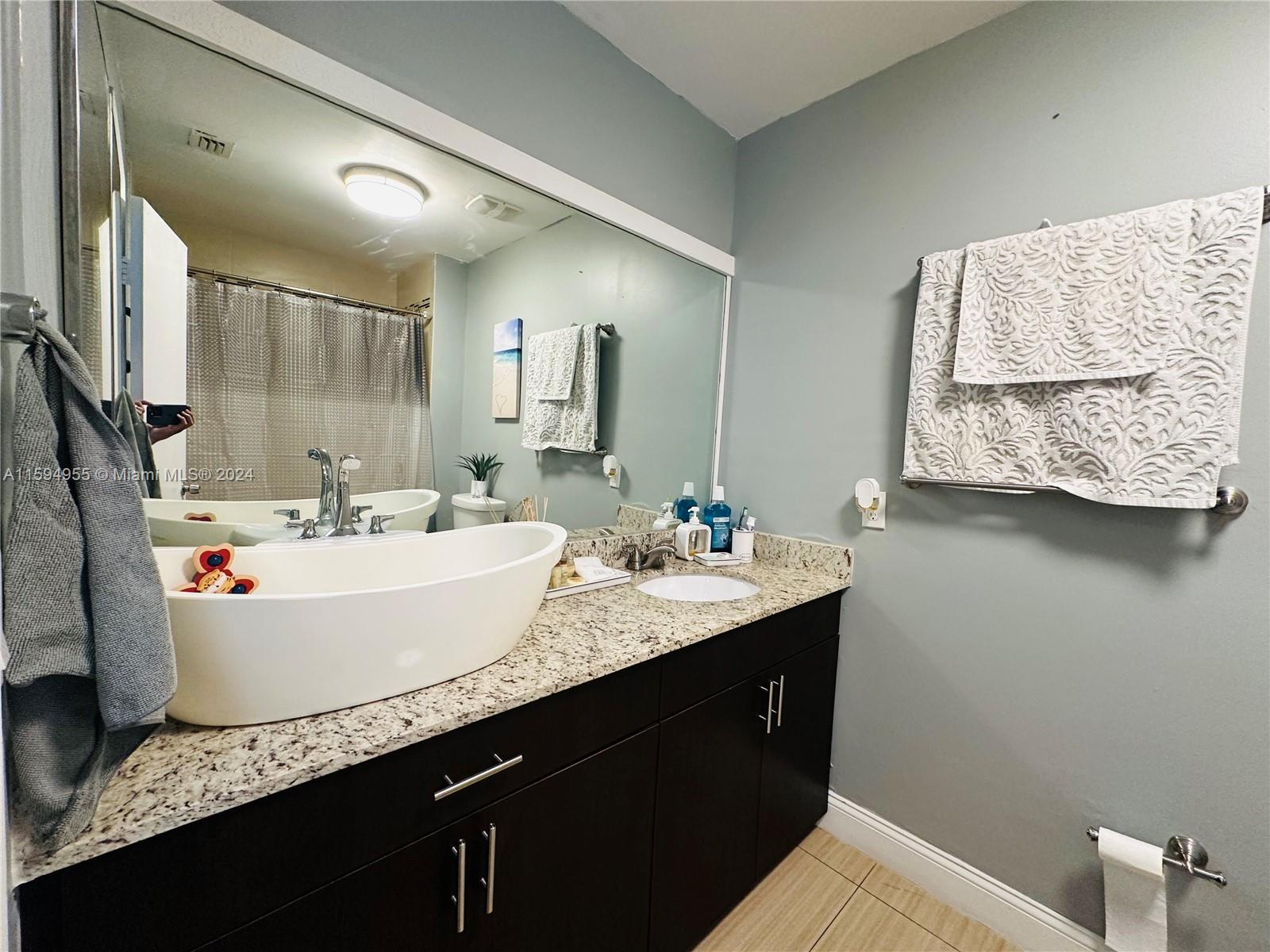 15056 Southwest 127th Place Miami, FL 33186 - Photo 15 of 25 a bathroom with a granite countertop sink a mirror and vanity