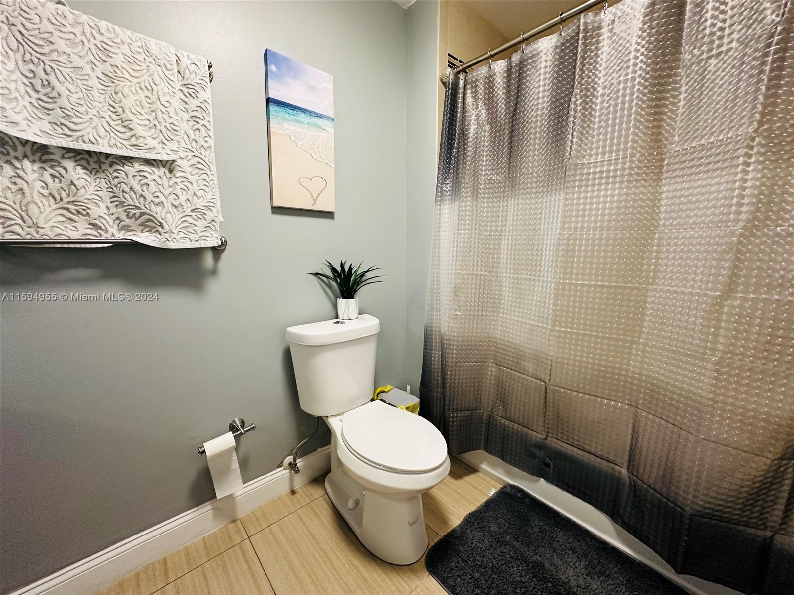15056 Southwest 127th Place Miami, FL 33186 - Photo 16 of 25 a white toilet sitting next to a bathroom sink