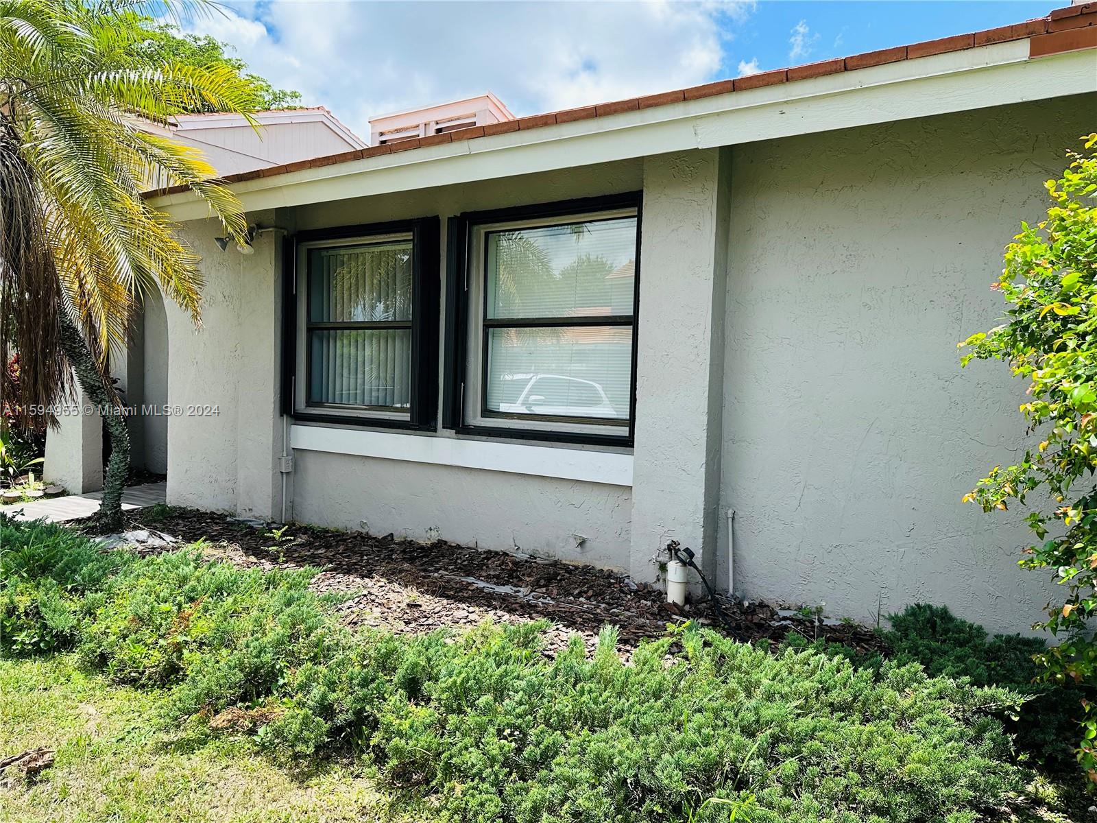15056 Southwest 127th Place Miami, FL 33186 - Photo 2 of 25 a front view of a house with a yard