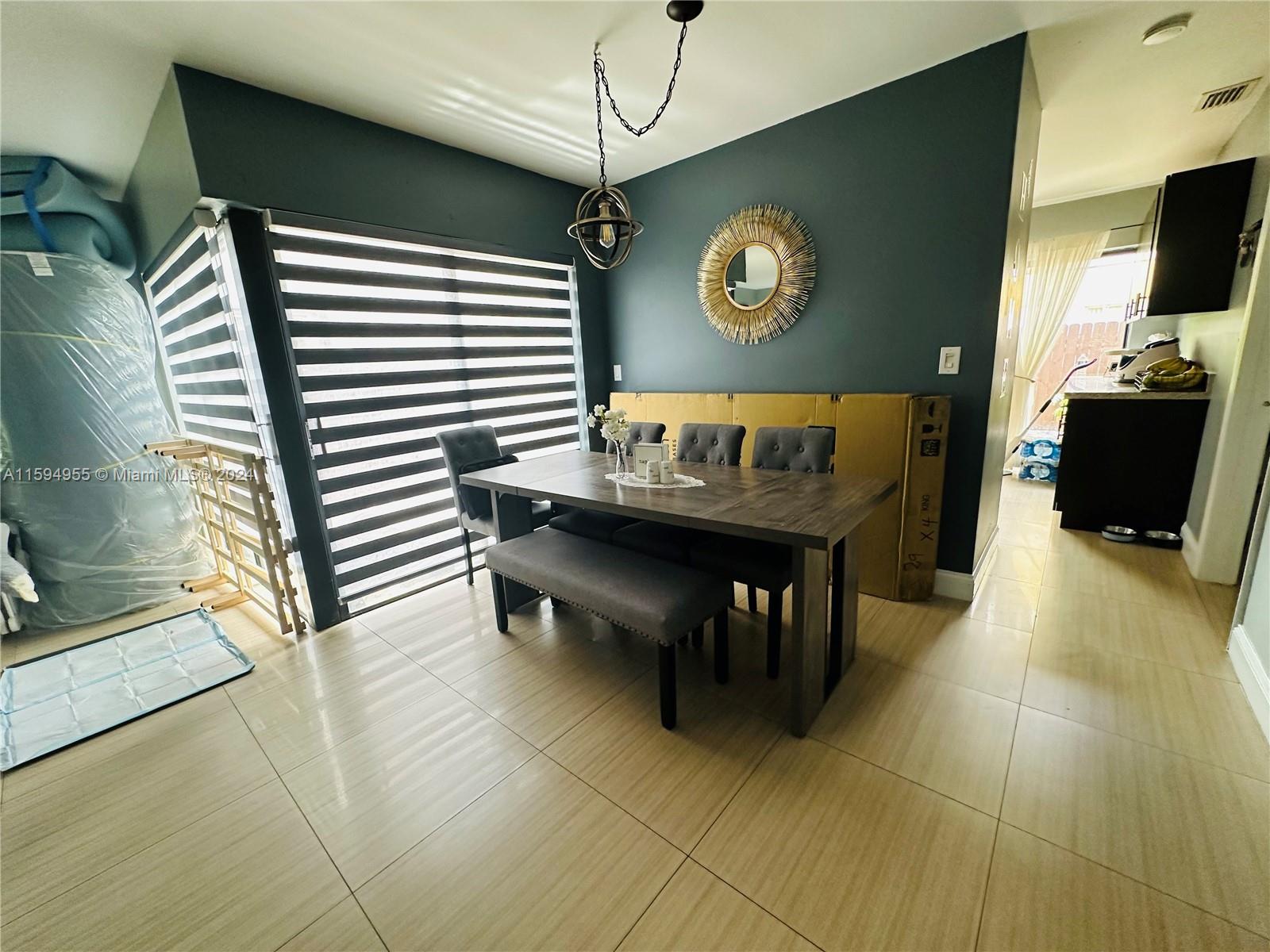 15056 Southwest 127th Place Miami, FL 33186 - Photo 4 of 25 a view of a dining room with furniture and a chandelier