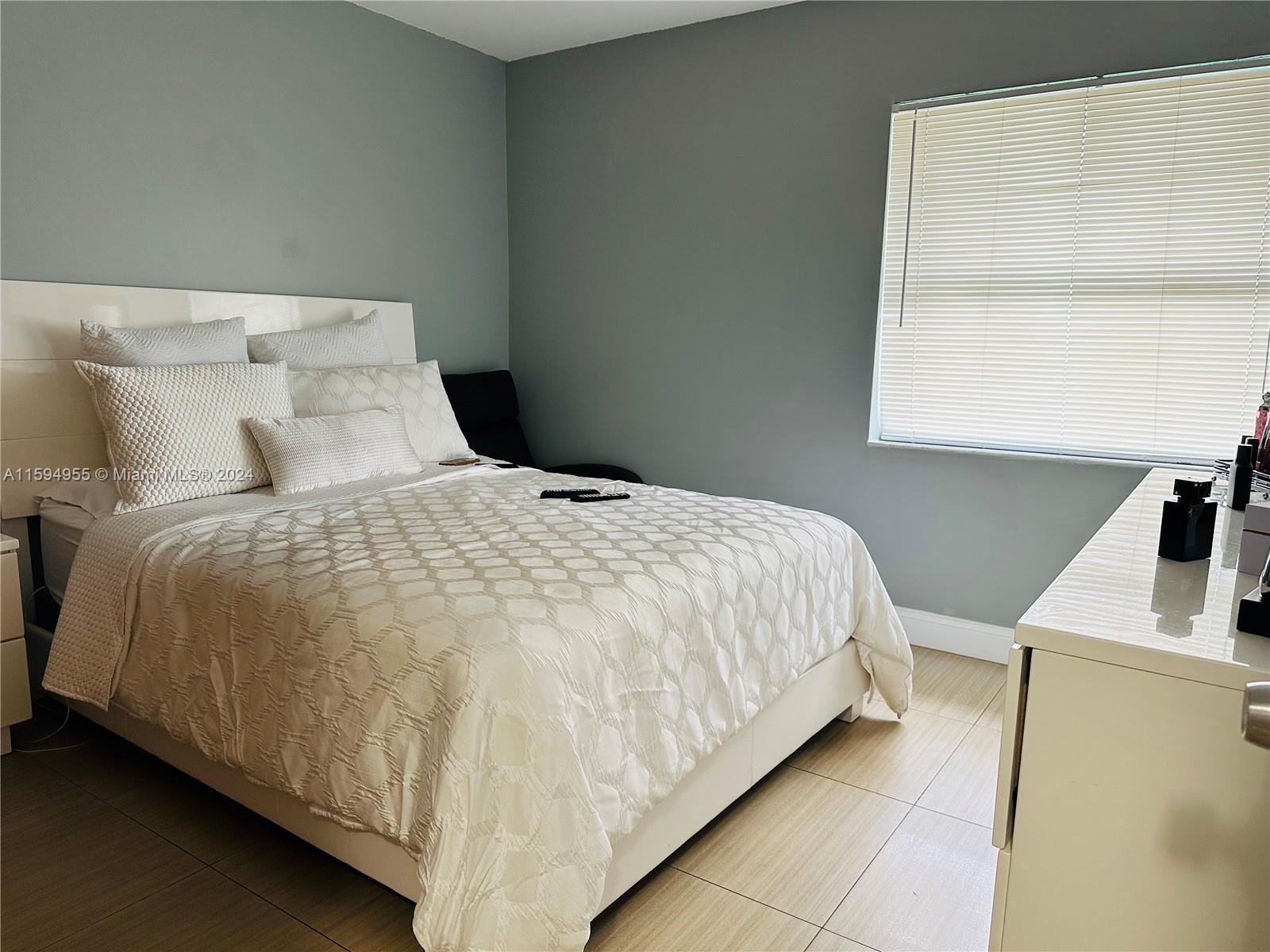 15056 Southwest 127th Place Miami, FL 33186 - Photo 5 of 25 a large bed sitting in a bedroom next to a window