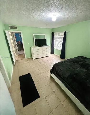 a bedroom with a bed and a television