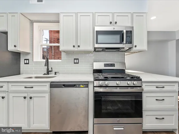 a kitchen with cabinets stainless steel appliances and a sink