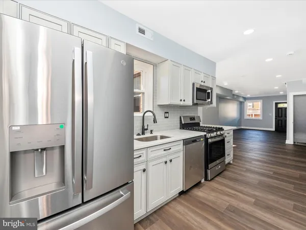 a kitchen with stainless steel appliances granite countertop a refrigerator stove and sink