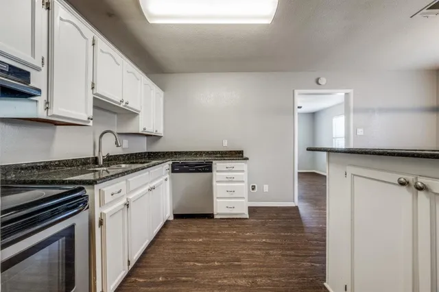 a kitchen with a stove and white cabinets