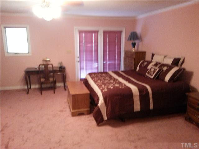 5005 Robinwood Road Durham, NC 27713 - Photo 3 of 6 a bedroom with a bed and a furniture