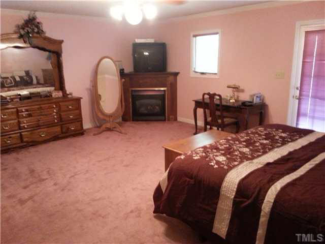 5005 Robinwood Road Durham, NC 27713 - Photo 4 of 6 a bed sitting in a bedroom and tv