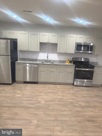 a large kitchen with stainless steel appliances granite countertop a stove a sink and a granite counter tops