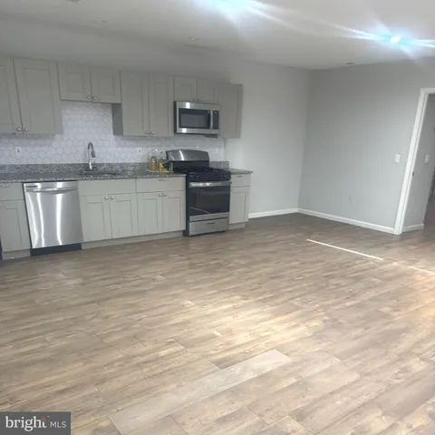 a kitchen with stainless steel appliances granite countertop a sink and a stove