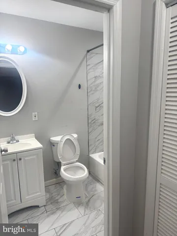 a bathroom with a toilet sink vanity and mirror