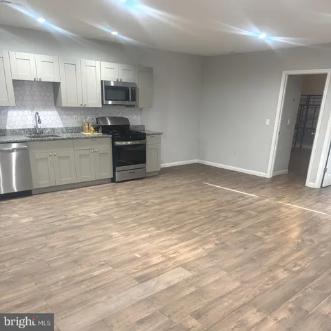 a kitchen with granite countertop a stove top oven a sink and a microwave