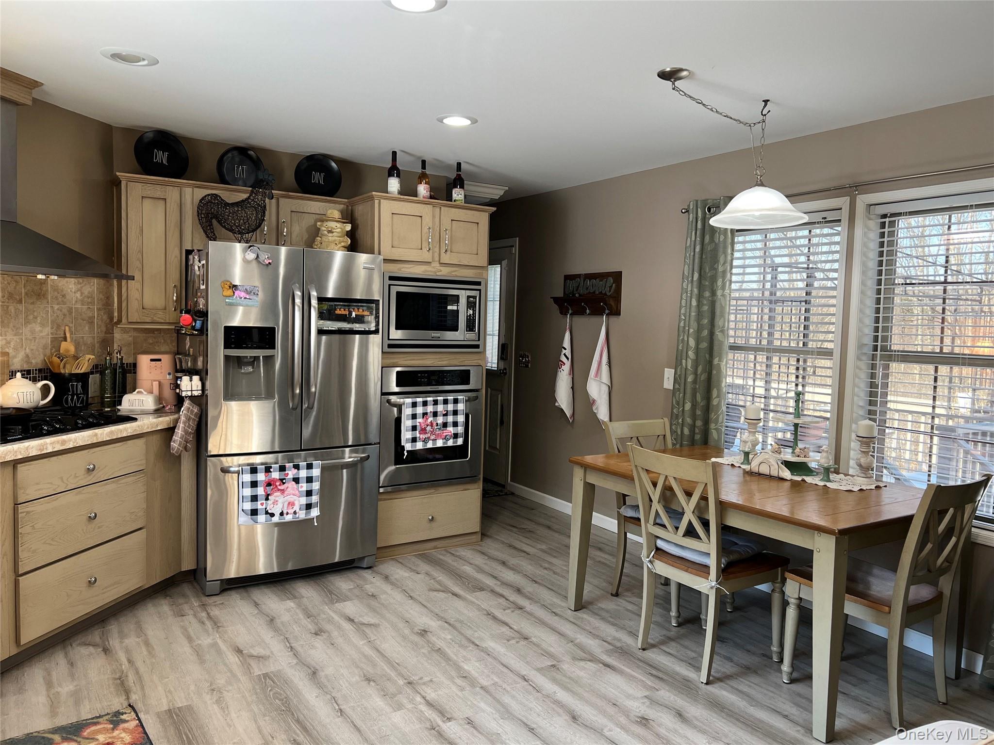 71 Midway Road Liberty, NY 12758 - Photo 8 of 23 a kitchen with stainless steel appliances kitchen island granite countertop a table chairs in it and wooden floors