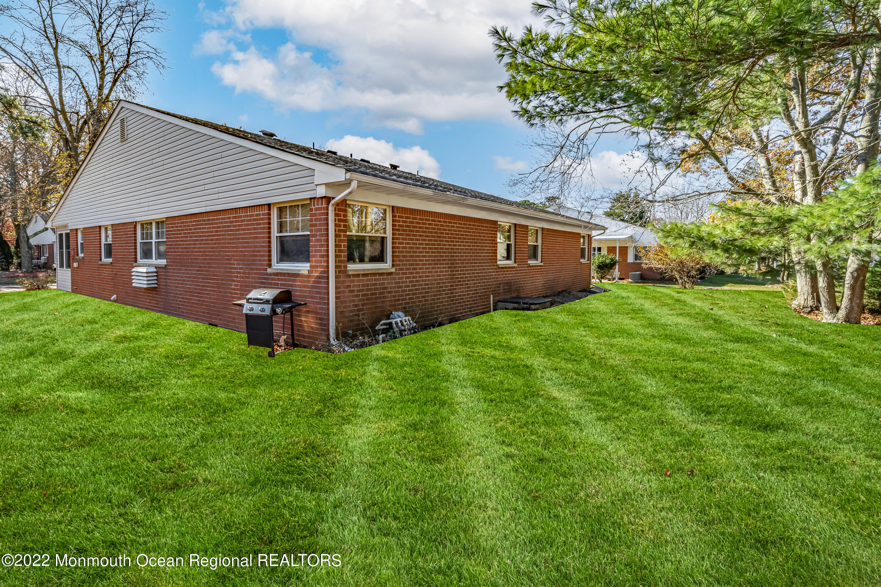 121 Constitution Boulevard, Unit B Whiting, NJ 08759 - Photo 20 of 20 a view of a backyard with potted plants and large tree