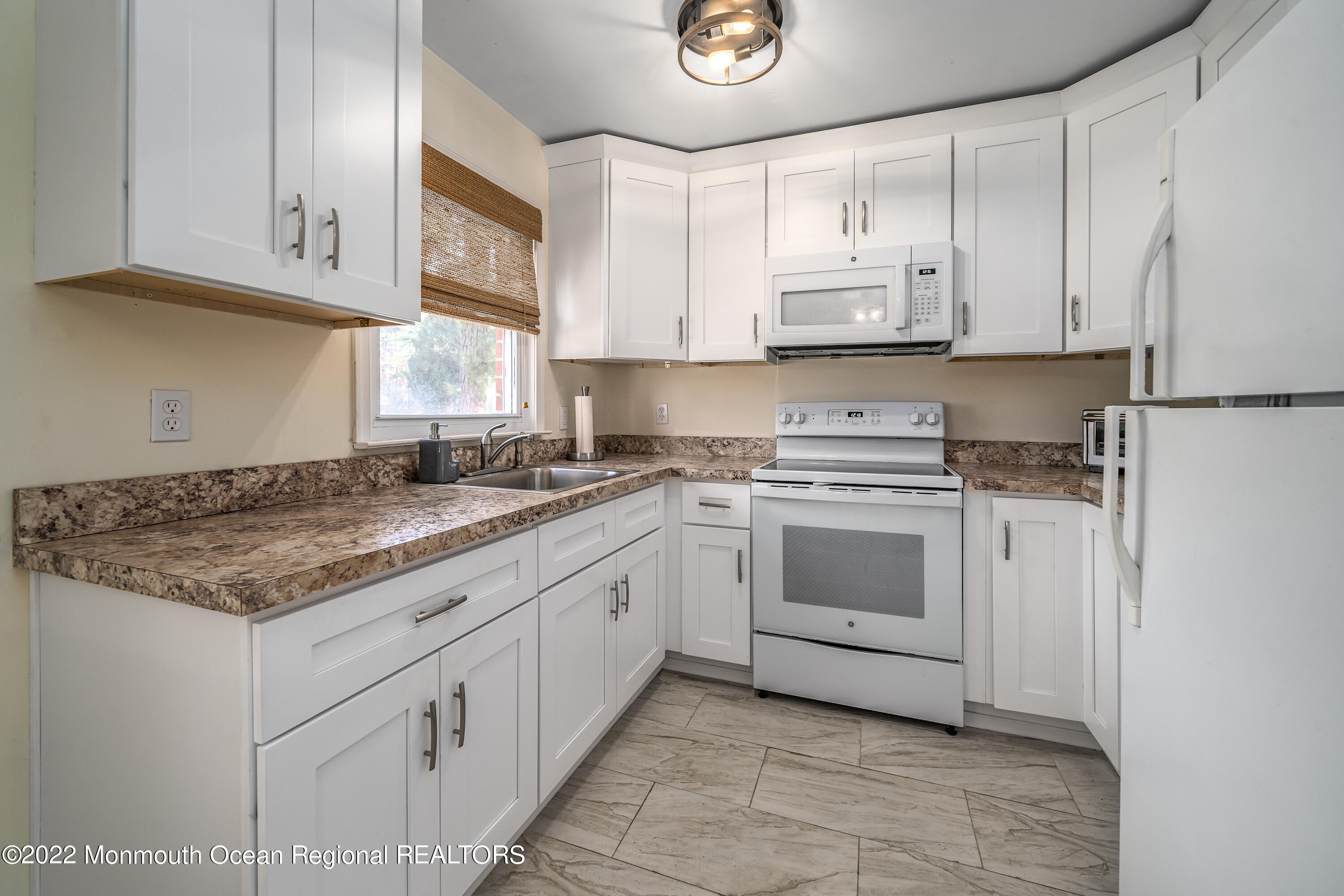 121 Constitution Boulevard, Unit B Whiting, NJ 08759 - Photo 8 of 20 a kitchen with granite countertop white cabinets and white appliances