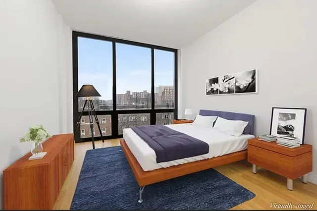 a bedroom with a bed and a large window