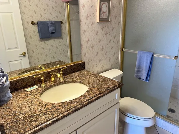 a bathroom with a granite countertop sink and a mirror