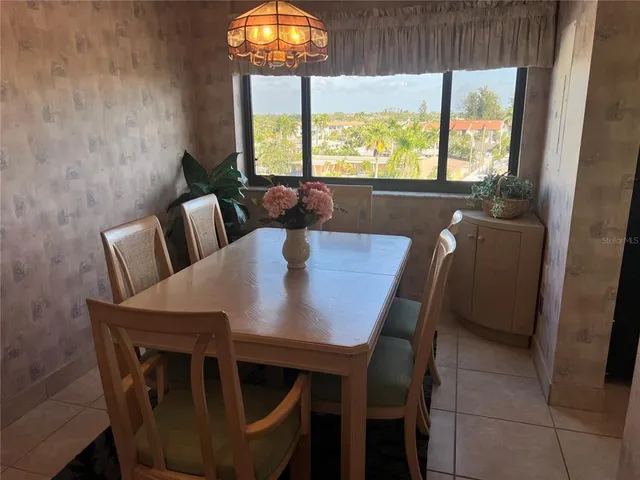 a view of a dining room with furniture a rug and wooden floor