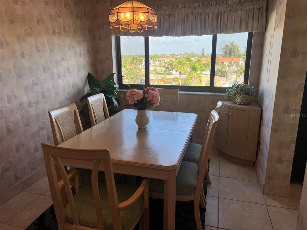 1001 Point Of Rocks Road, Unit 508 Sarasota, FL 34242 - Photo 6 of 34 a view of a dining room with furniture a rug and wooden floor