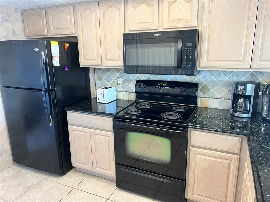 1001 Point Of Rocks Road, Unit 508 Sarasota, FL 34242 - Photo 7 of 34 a kitchen with granite countertop cabinets and steel stainless steel appliances