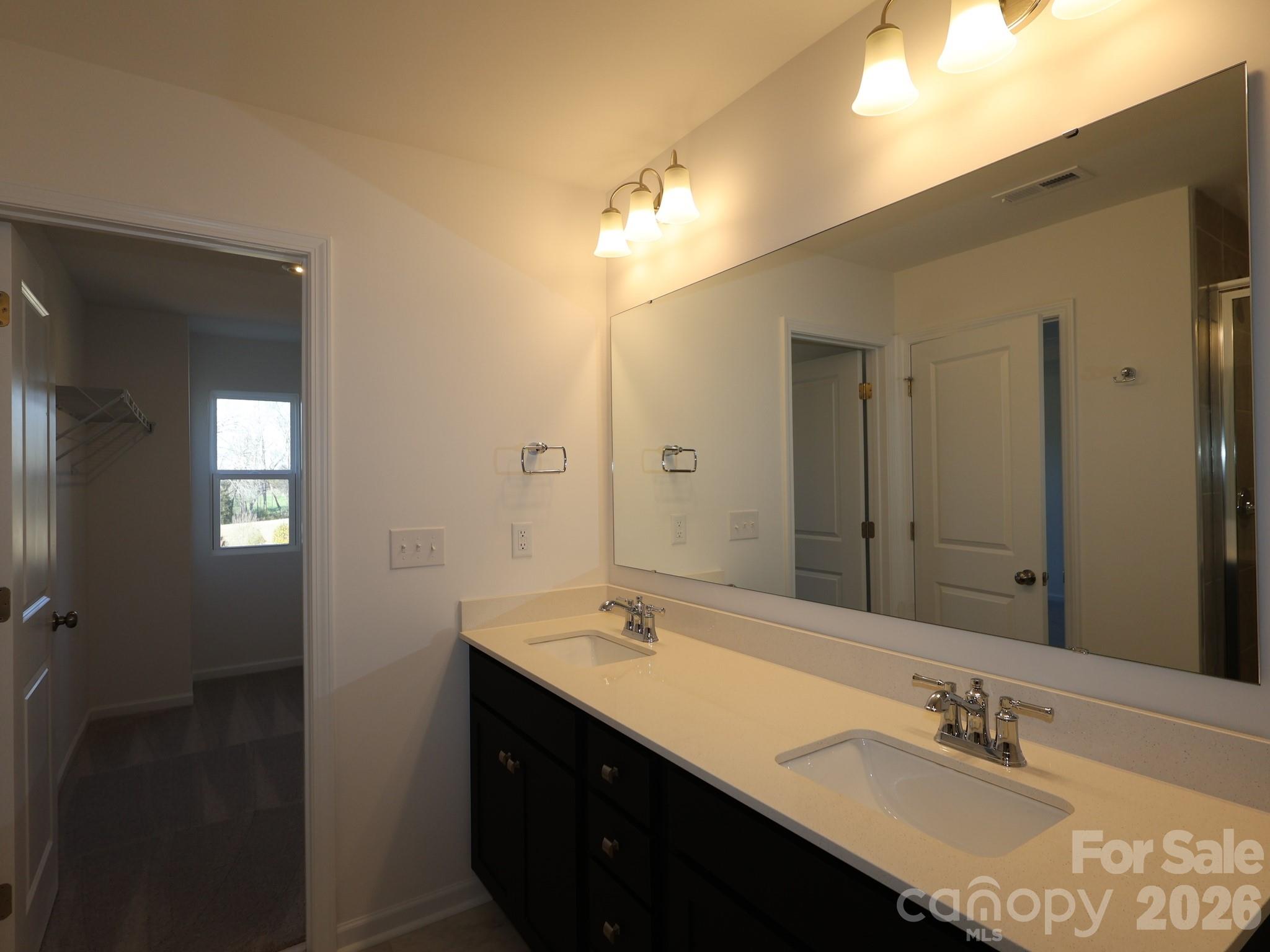 1152 Overbrook Place Wingate, NC 28174 - Photo 19 of 19 a bathroom with a double vanity sink a mirror and a shower
