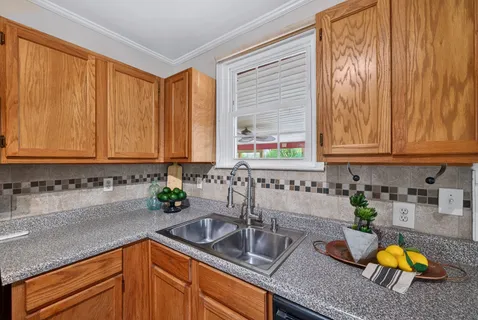 a kitchen with sink a window and cabinets