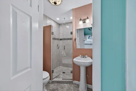 a bathroom with a sink a toilet and shower