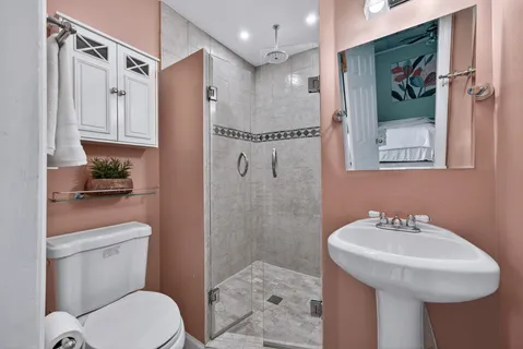 a bathroom with a sink a toilet and shower