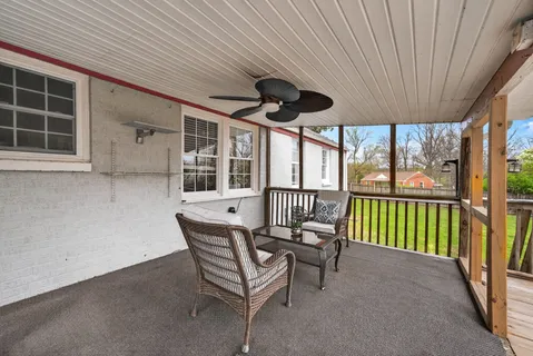a view of a porch with furniture and floor to ceiling window