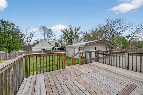 a view of a wooden deck and a backyard