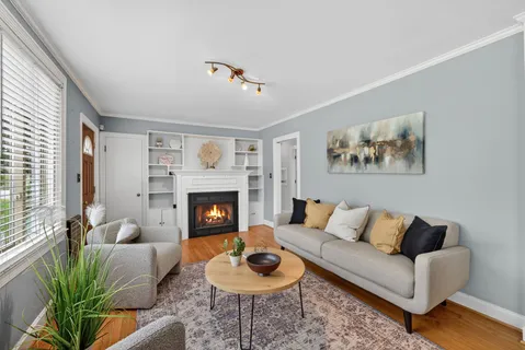 a living room with furniture a fireplace and a large window