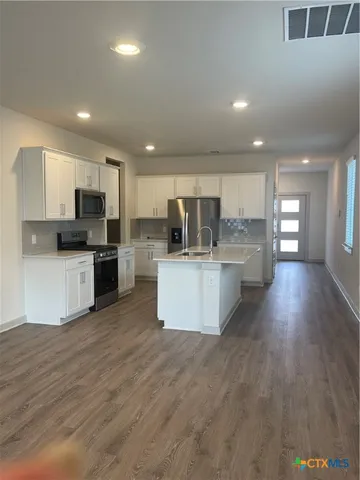 a large kitchen with a center island and stainless steel appliances