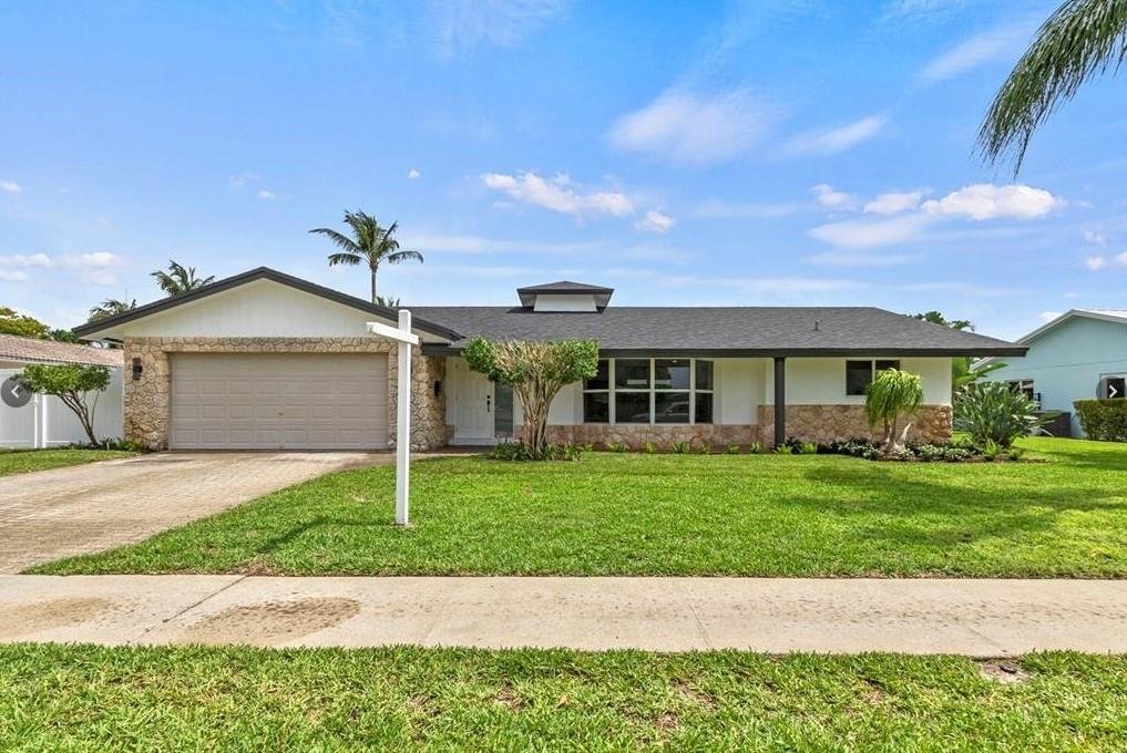 1365 Southwest 14th Street Boca Raton, FL 33486 - Photo 11 of 12 a front view of a house with a yard and garage