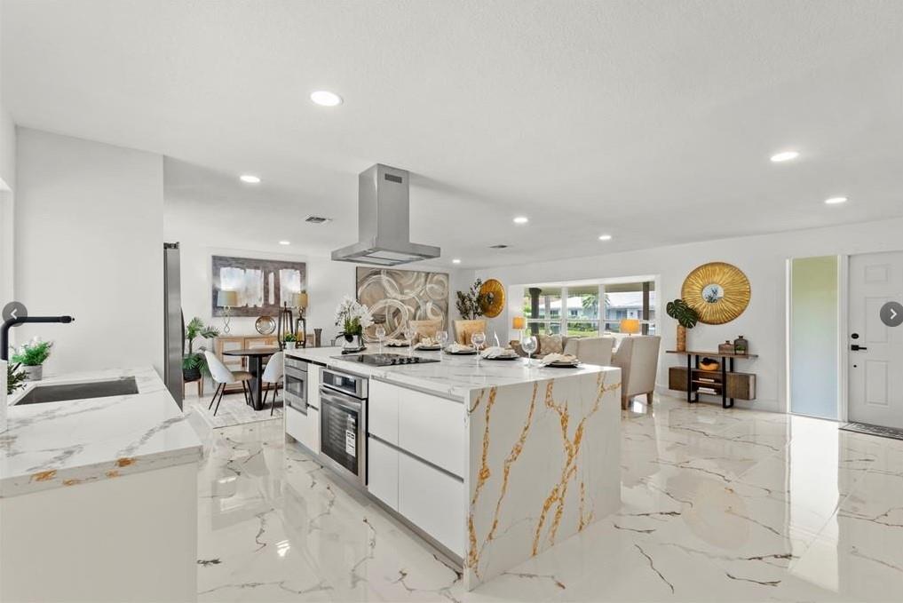 1365 Southwest 14th Street Boca Raton, FL 33486 - Photo 3 of 12 a kitchen with stainless steel appliances granite countertop a stove and a view of living room
