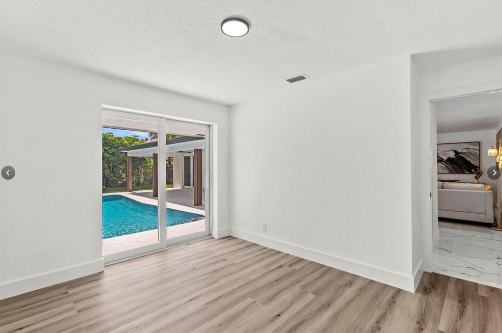 1365 Southwest 14th Street Boca Raton, FL 33486 - Photo 7 of 12 an empty room with wooden floor and a window
