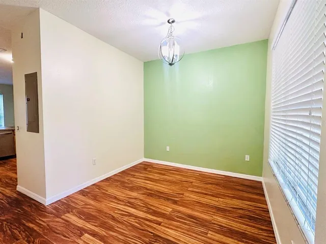 a view of a room with wooden floor and chandelier