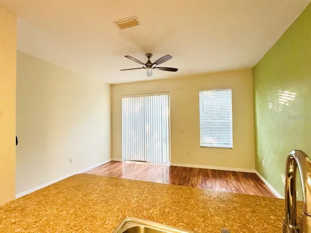 a view of a livingroom with a chandelier fan and wooden floor