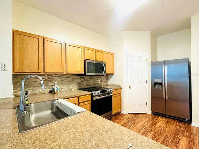 a kitchen with stainless steel appliances granite countertop a sink stove and refrigerator