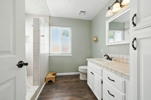 a spacious bedroom with a bed a chandelier and a window