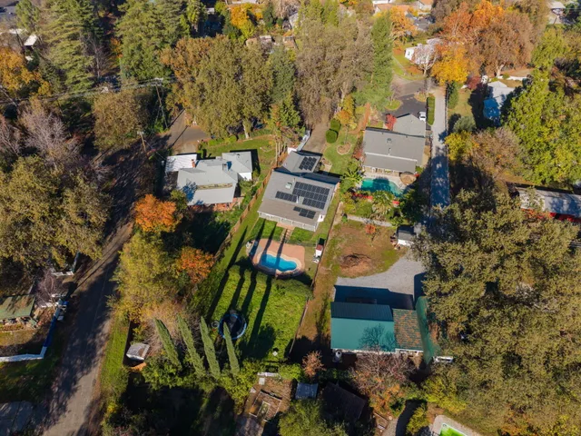 an aerial view of a house with swimming pool outdoor seating and yard