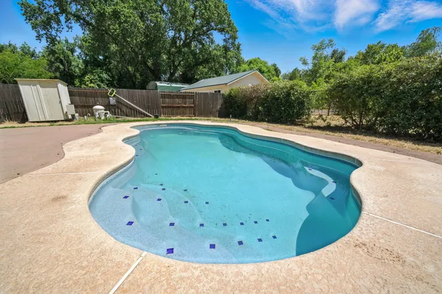 a view of a swimming pool with a yard