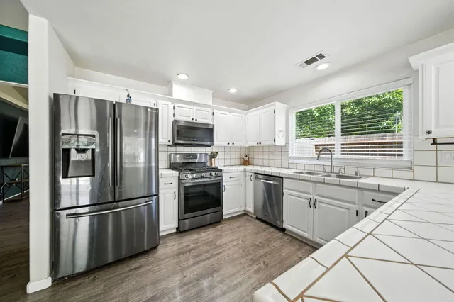 a kitchen with a sink stove top oven and refrigerator