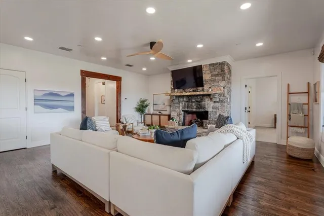 a living room with furniture a flat screen tv and a fireplace