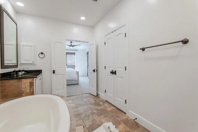 a spacious bathroom with a granite countertop sink and a mirror