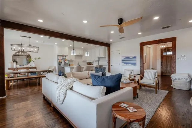 a living room with furniture kitchen view and a large window