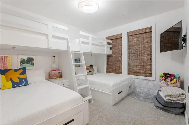 a bedroom with bed and a flat tv screen